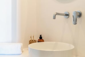 A bathroom with a white sink, a towel, and a soap dispenser.
