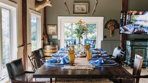 Comedor con una mesa de madera dispuesta para seis personas, rodeada de sillas de cuero.