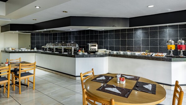 A modern kitchen with a buffet setup, including a coffee machine and various food items. - African Sky Hotels - Harrismith Inn (Maluti a Phofung)