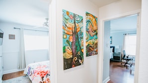 Ein Schlafzimmer mit einem Bett, einem Fenster und zwei Bildern an der Wand.