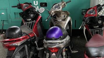 Three motorcycles parked in front of a green wall with a sign that reads "POWER GENERATION 30 KVA".