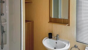 Un bagno con doccia, lavandino, specchio e WC.