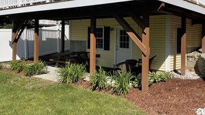 A two-story house with a covered porch and a small deck.