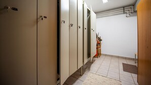 Eine Reihe von Schließfächern mit einer Bank und einem Mülleimer in einem Flur.