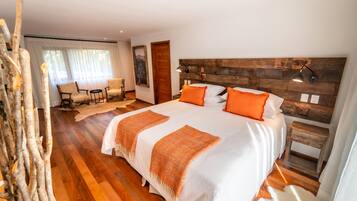 Quarto com cama grande, cabeceira de madeira e mesa de cabeceira pequena.