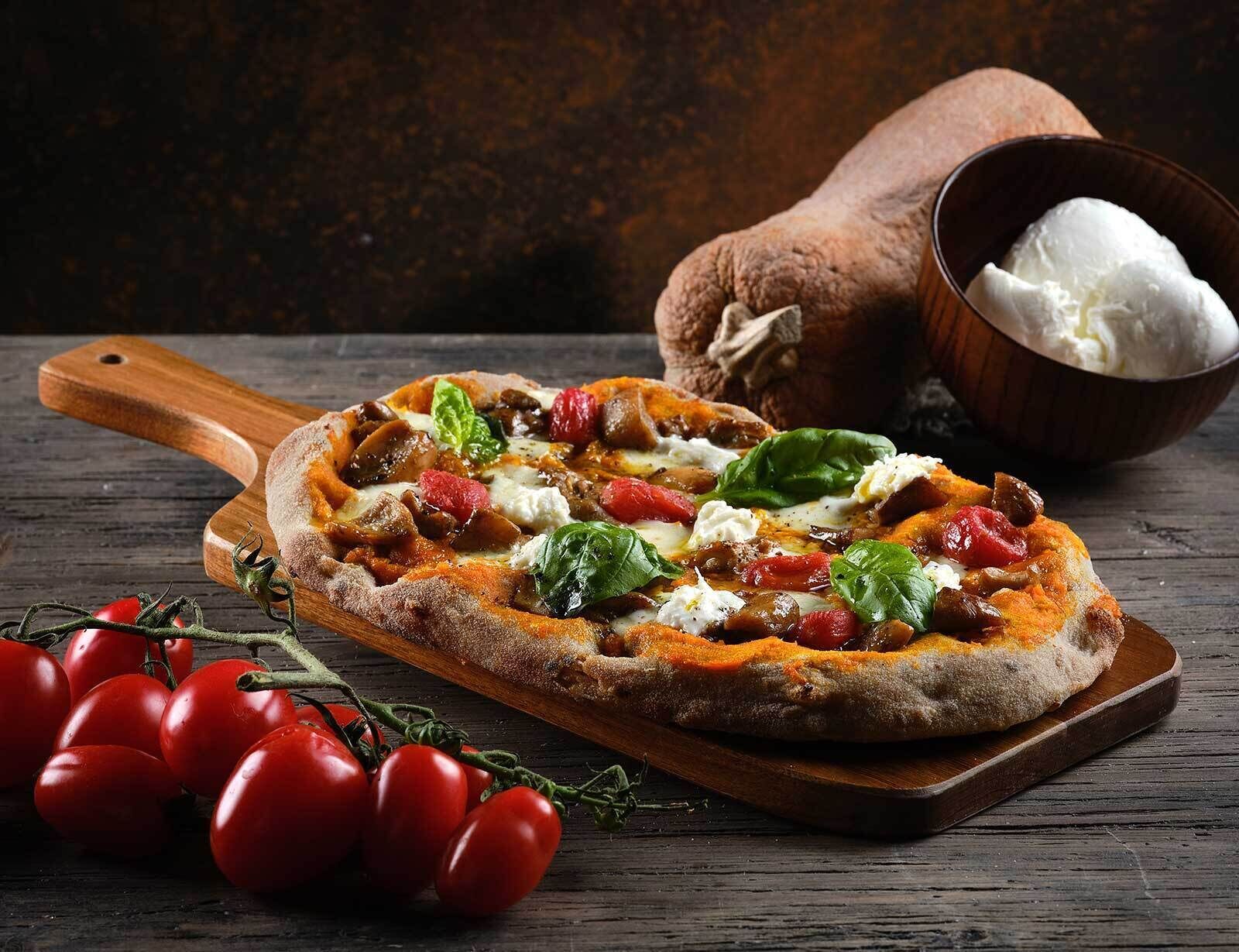 A pizza on a wooden board with a rustic background.