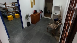 Una habitación compacta con literas, un escritorio pequeño, una silla y un televisor.