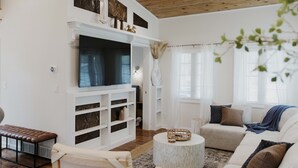 A modern living room with a fireplace, a sofa set, and a television.