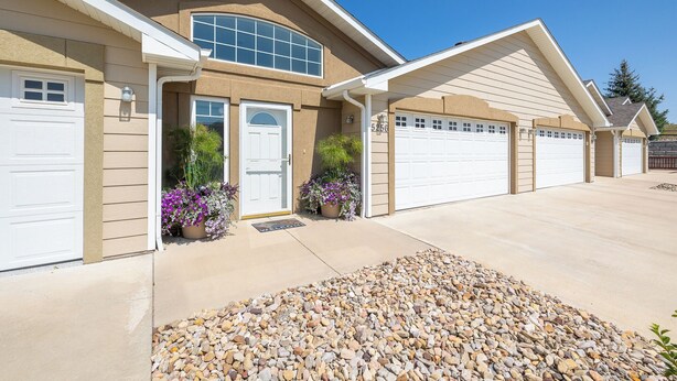 A residential house with a garage, a front door, and a driveway. - Two bedroom townhome, central to most popular destinations within Rapid City.   (Rapid City)