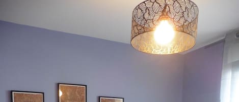 A bedroom with a bed, a nightstand, and three framed maps on the wall.