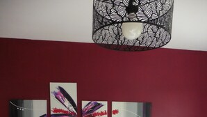 A hotel room with a bed, two bedside tables, and a wall-mounted artwork.