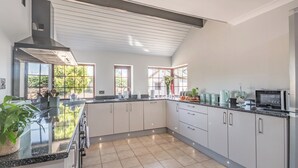 A modern kitchen with a large island, ample counter space, and a view of the outdoors. - 4 bedroom accommodation in Llysfaen, near Colwyn Bay (Llysfaen, near Colwyn Bay)