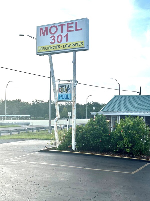 Placa de motel com o número 301 e um aviso de piscina com TV.