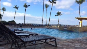 A pool area with lounge chairs and palm trees. - Sugar Beach Oceanfront Condo with Spectacular Views and Steps to Beach (Kihei)
