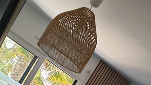 Une chambre à coucher avec un lit, une fenêtre et un luminaire suspendu.