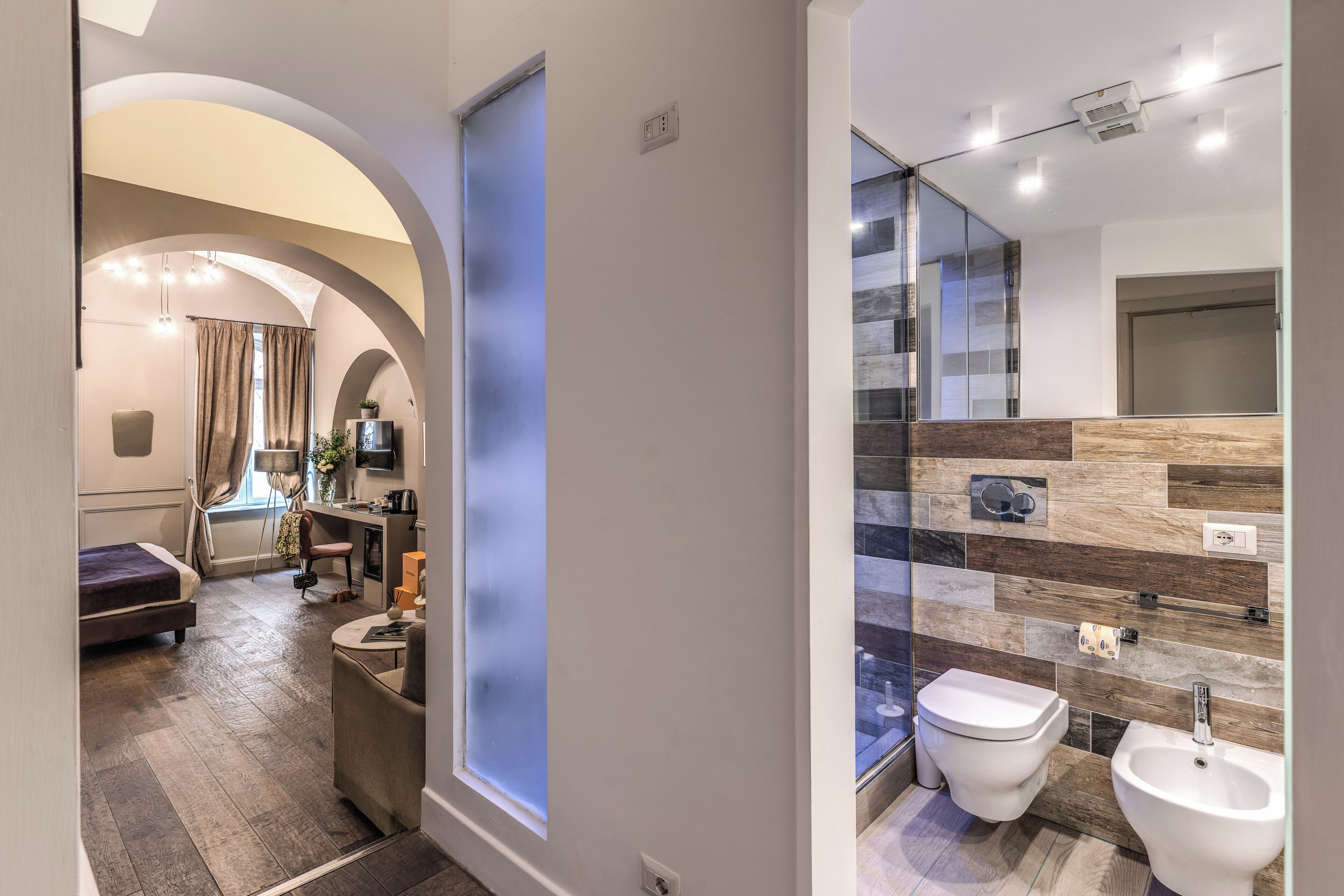 Un baño moderno con cabina de ducha de vidrio, un bidé y un inodoro.