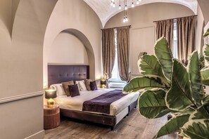 A bedroom with a large bed, a nightstand, a lamp, and a window with curtains. - Telier Tomacelli (Rome)