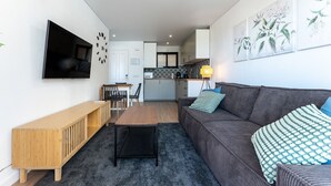 A modern living room with a sofa, a coffee table, and a TV mounted on the wall. - Charming apartment near beach, sea view  REF038 (Torremolinos)