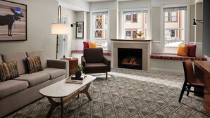 A cozy living room with a fireplace, a sofa, a chair, and a coffee table.
