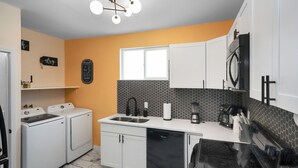 Uma cozinha compacta com lava-louças, micro-ondas e pia.