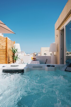 A rooftop hot tub with a table and chairs, surrounded by a wooden fence and a lamp. - GIORGIO BOUTIQUE HOTEL (Sliema)