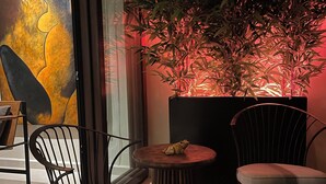 Ein modernes Interieur mit Glastür, zwei Stühlen, einem kleinen Tisch und einem Blumentopf.