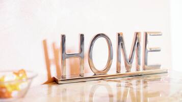 Ein metallisches Schild mit dem Wort „HOME“ auf einer spiegelnden Oberfläche.