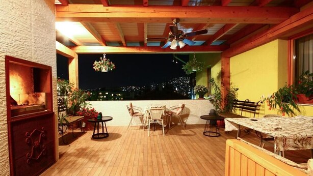 Une terrasse extérieure avec un plancher en bois, un ventilateur de plafond et une table avec des chaises.
