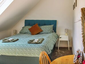 Une chambre à coucher avec un lit, une table de chevet, une chaise et une table.
