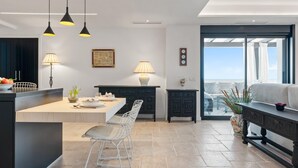 A modern kitchen with a central island, pendant lighting, and a view to the outside. - Apartment in Playas del Duque for 5 people | Casa Cadiz 412A (Puerto Banús - Marbella)