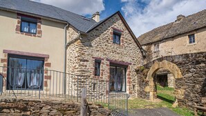 Ein Steinhaus mit geneigtem Dach, einem kleinen Fenster und einem steinernen Bogen.