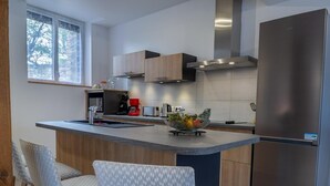 Eine moderne Küche mit einer zentralen Kochinsel, Edelstahlgeräten und Holzkorpussen.