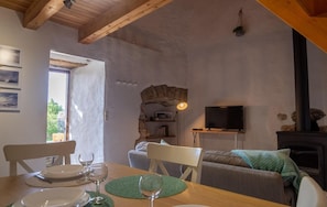 Cozy living space with a high ceiling, exposed beams, and a fireplace, perfect for relaxing.