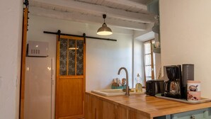 A compact kitchen with a wooden island, a built-in sink, and a coffee maker.