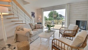 Een moderne woonkamer met een bank, stoelen, een salontafel en een televisie.