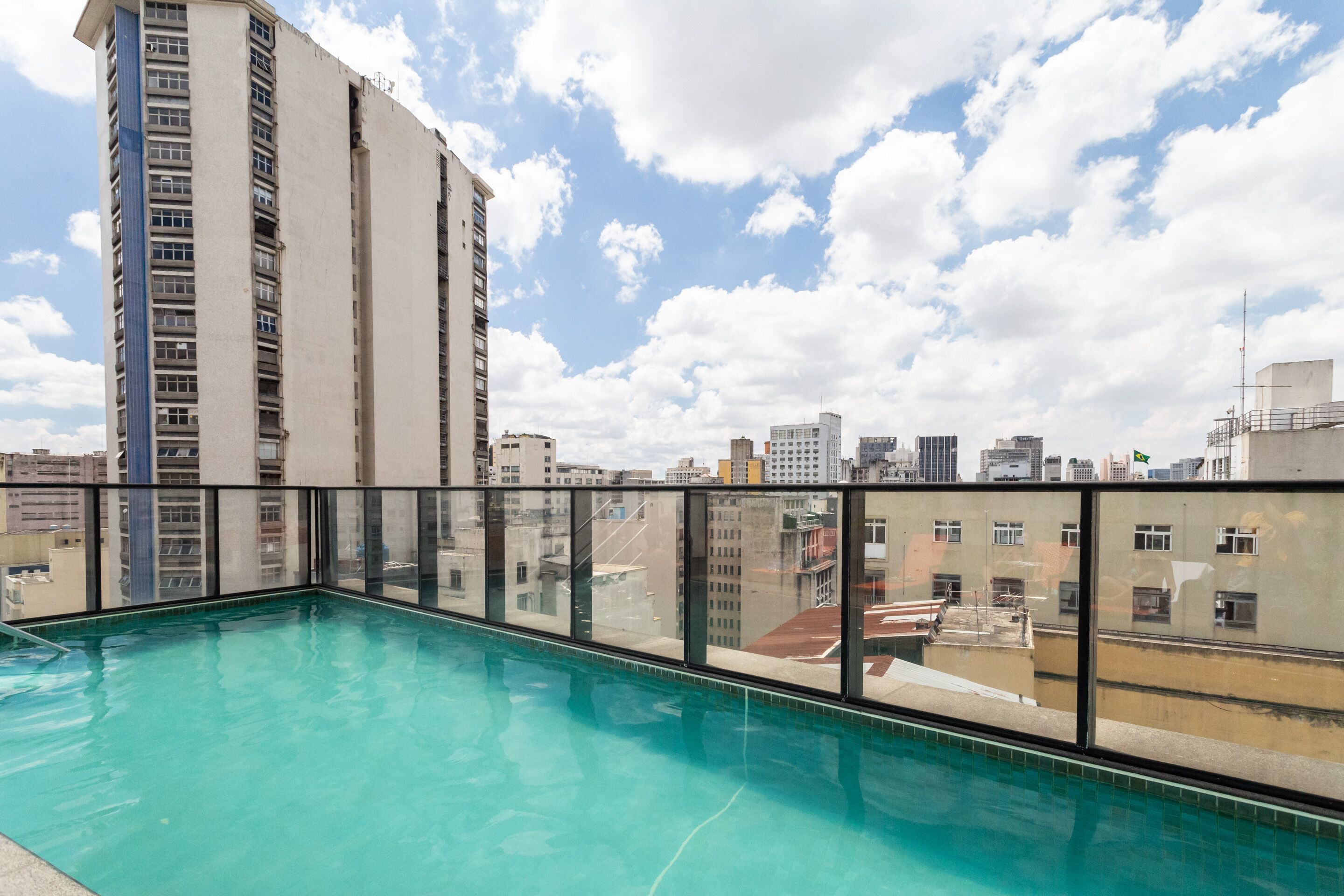 A rooftop pool with a cityscape view, surrounded by high-rise buildings.