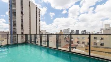 A rooftop pool with a cityscape view, surrounded by high-rise buildings.