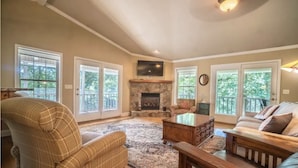 A spacious living room with a fireplace, large windows, and a cozy seating area. - Lake Chatuge beauty w/private dock, fire pit, pool table, grills and A+ views! (Hayesville)