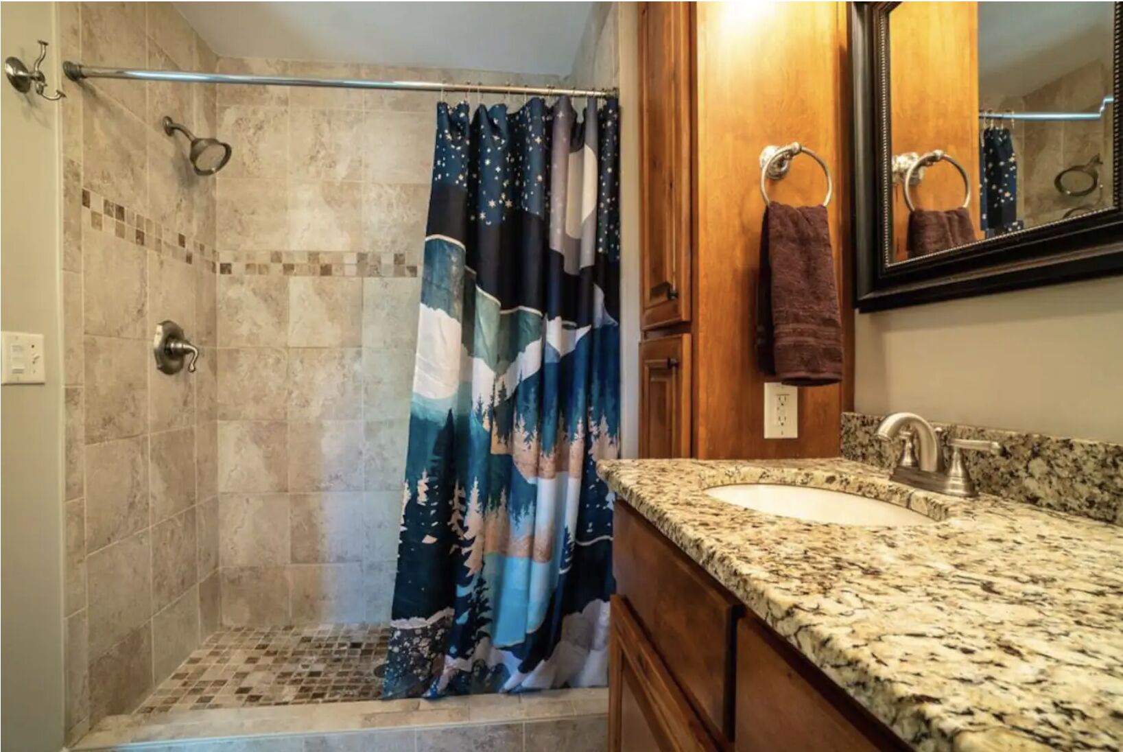 Un baño con ducha, lavamanos y espejo.