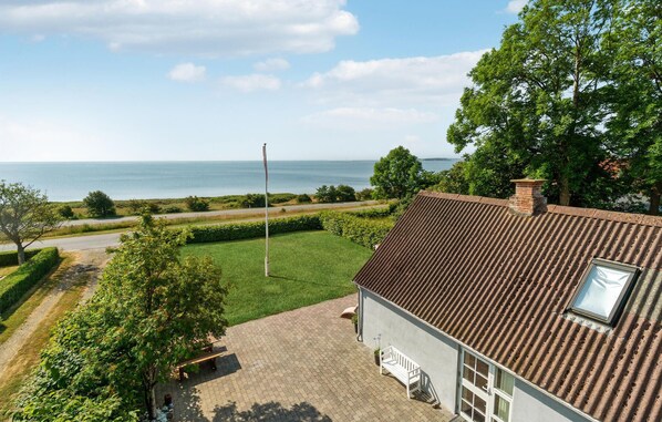 Enjoy a serene sea view from this property's lawn and porch area.