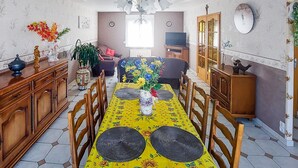 A dining area with a long table, chairs, and a floral tablecloth. - Awesome home in Quoux-Haut-Maînil with WiFi (Quoux-Haut-Maînil)
