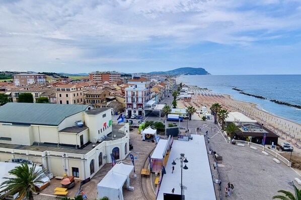 Un pueblo costero con edificios, una playa y un paseo marítimo.