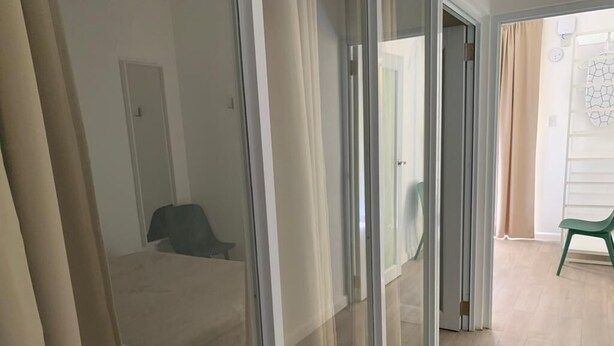 Et hotelværelse med en seng, en stol og en skydedør til en balkon.