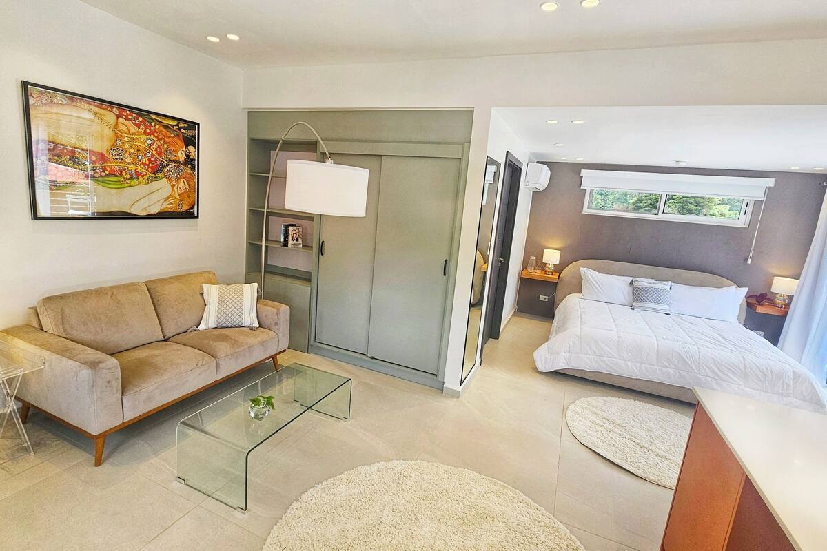 A modern living room with a sofa, coffee table, and a painting on the wall.