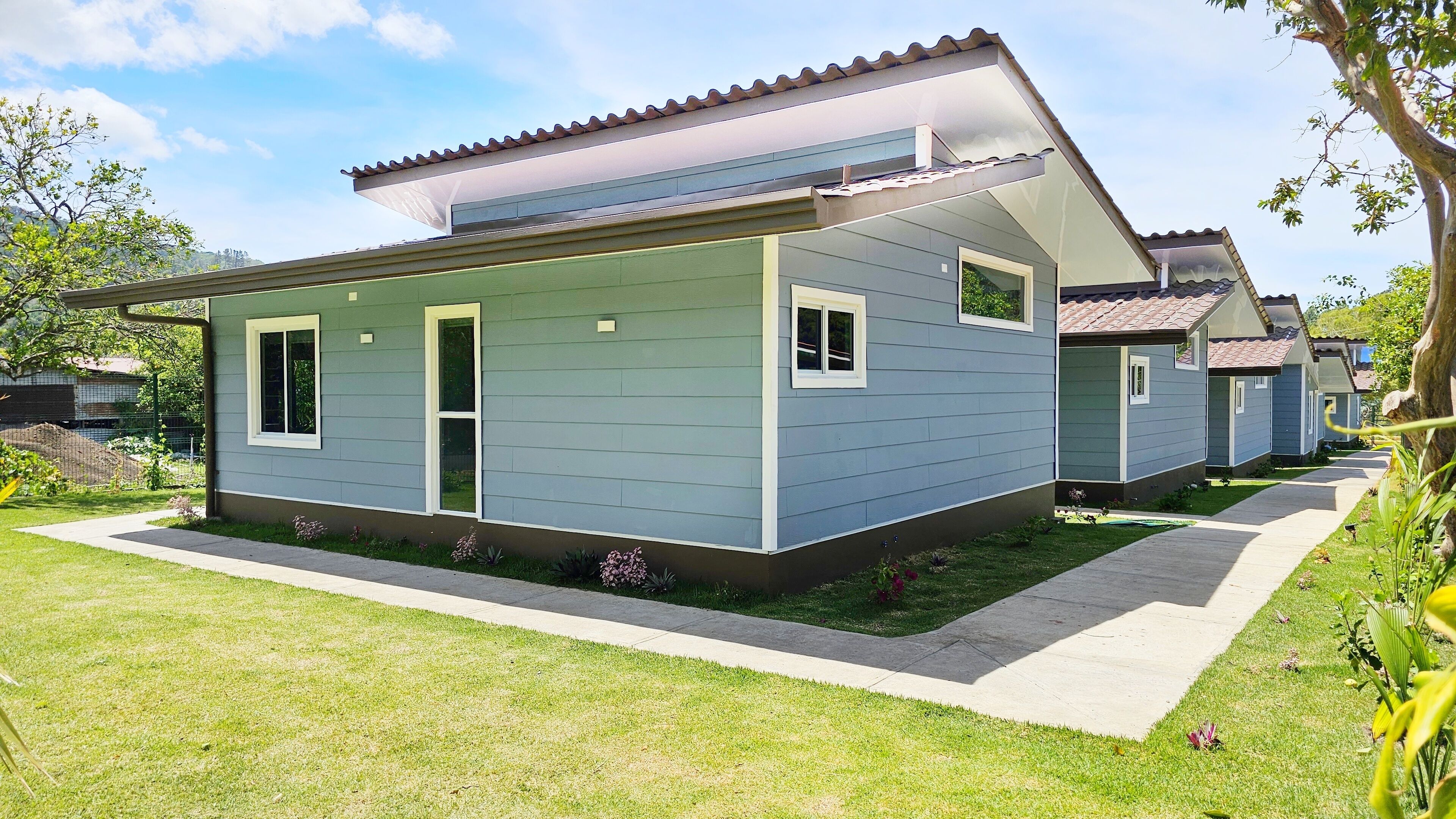 A modern two-story house with a flat roof and a covered porch.