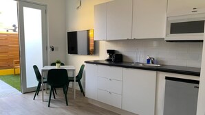 Una cocina moderna con armarios blancos, encimera negra y microondas integrado.