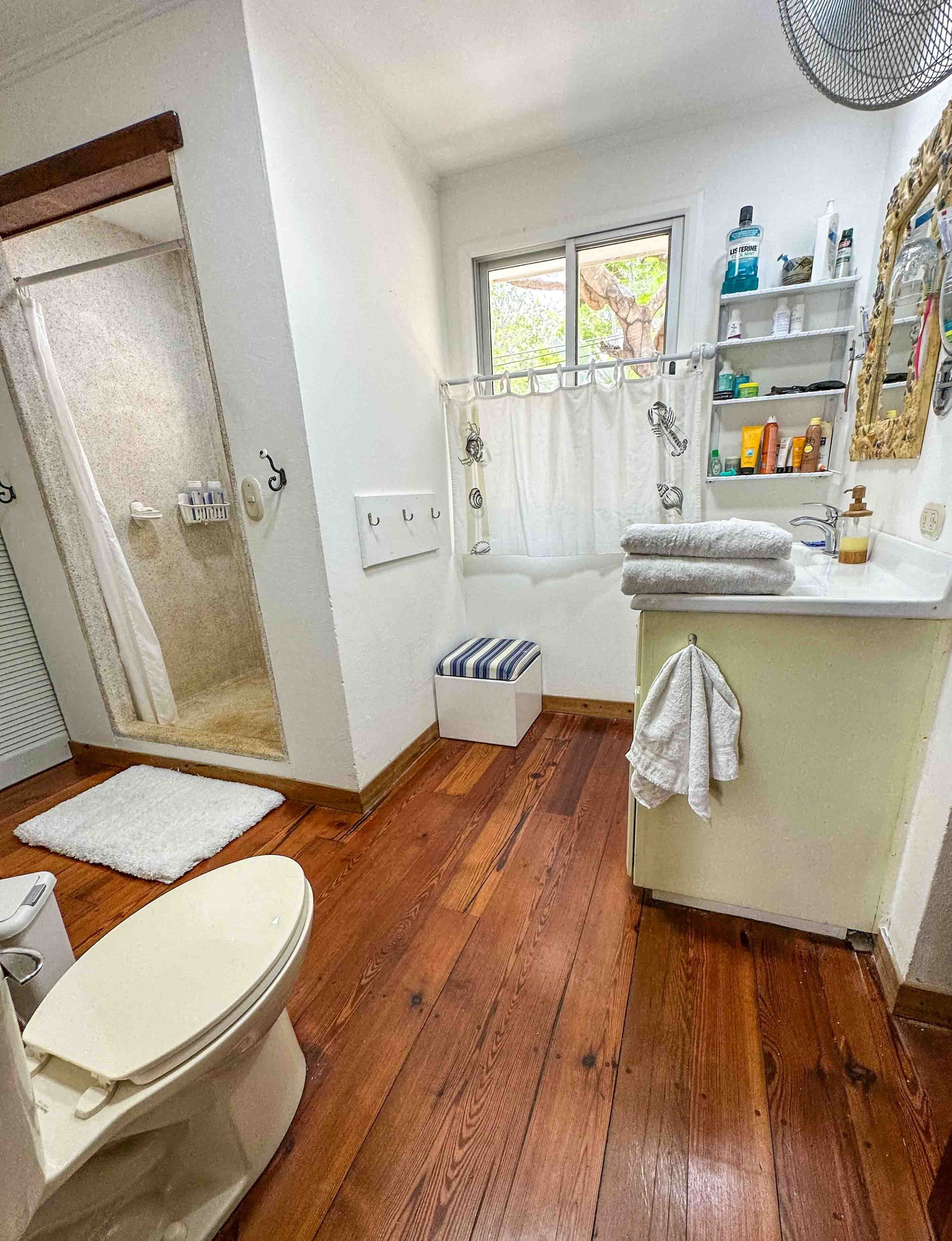 Een badkamer met een douche, toilet en wastafel.