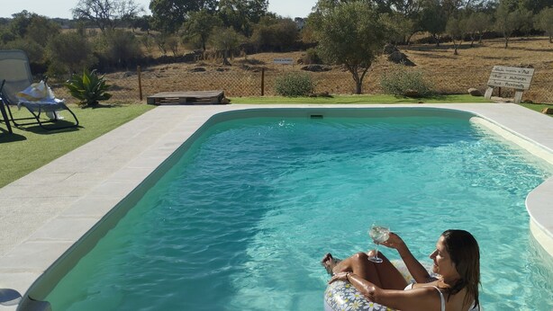 A rectangular swimming pool with clear blue water, surrounded by a paved deck. - Monte Típico Alentejano (Escoural)