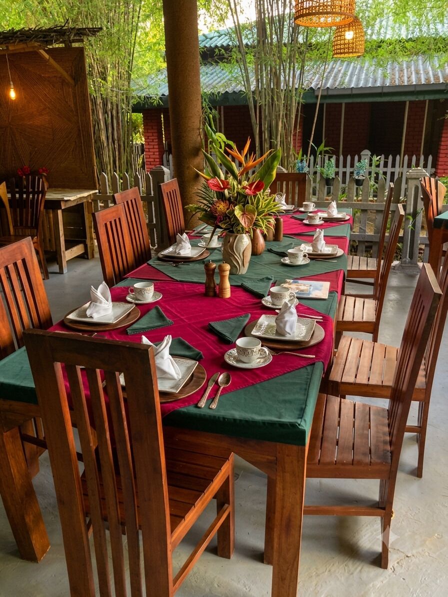 A dining area with wooden tables and chairs, red tablecloths, and a bamboo backdrop.