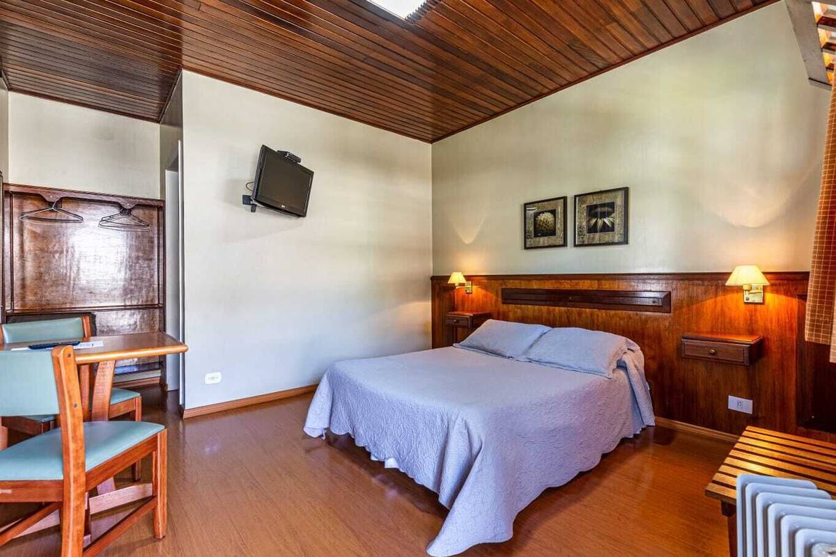 Een hotelkamer met een bed, een bureau en een stoel.